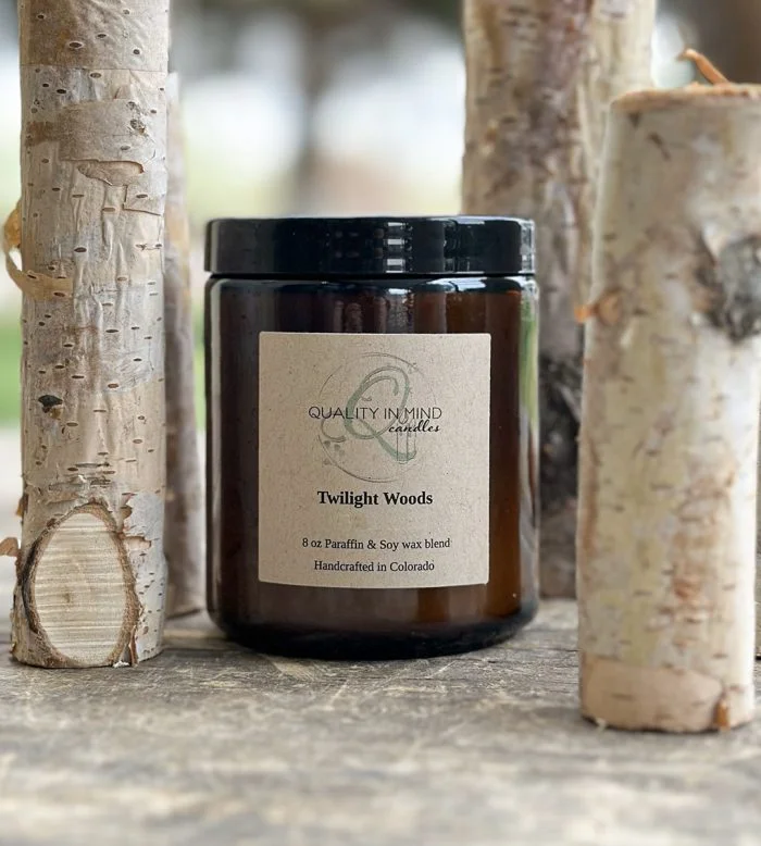 Handmade Candle displayed with tree stumps in Twilight Woods scent